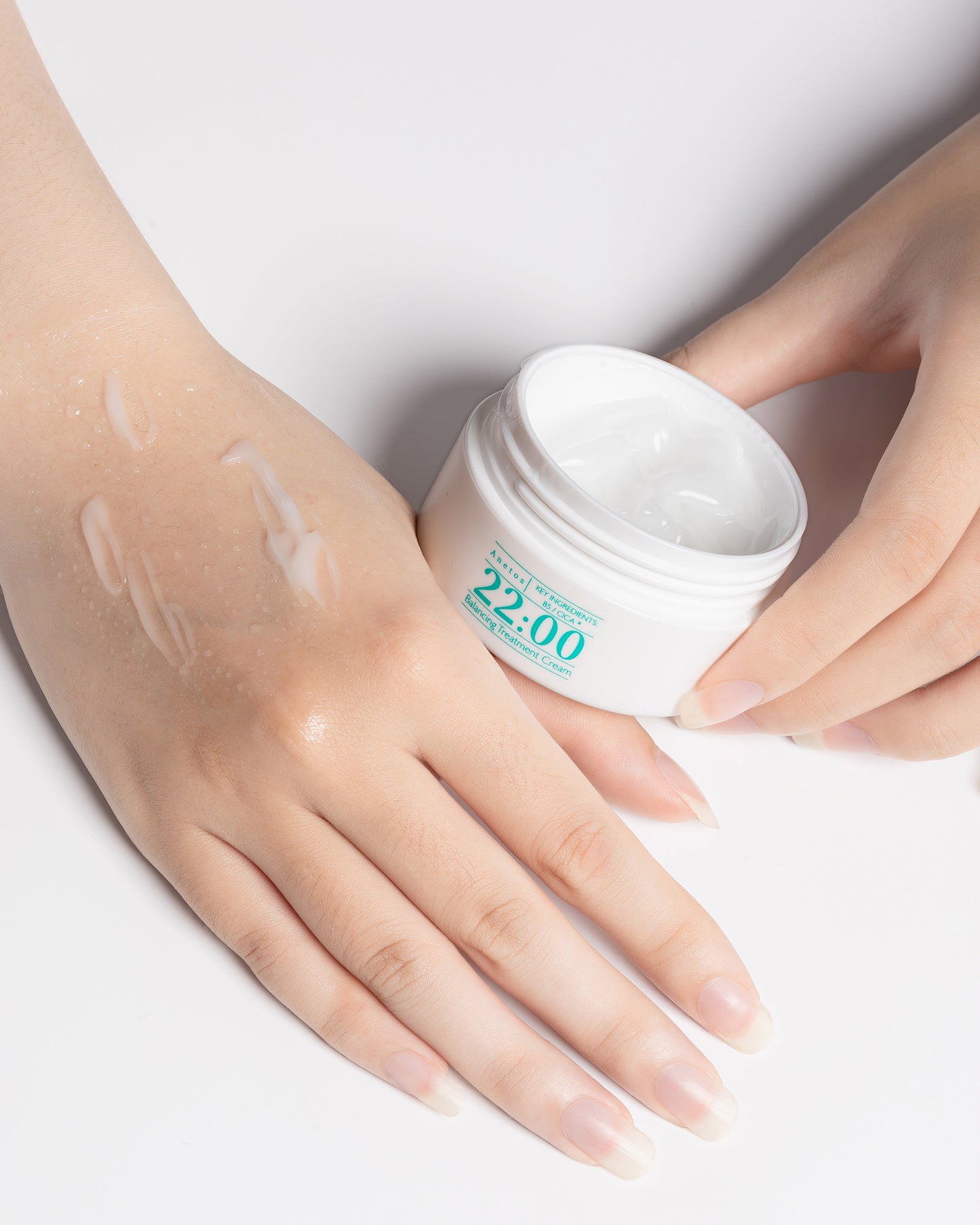 アネトス バランシング トリートメント クリームを塗った手とクリームの容器の画像